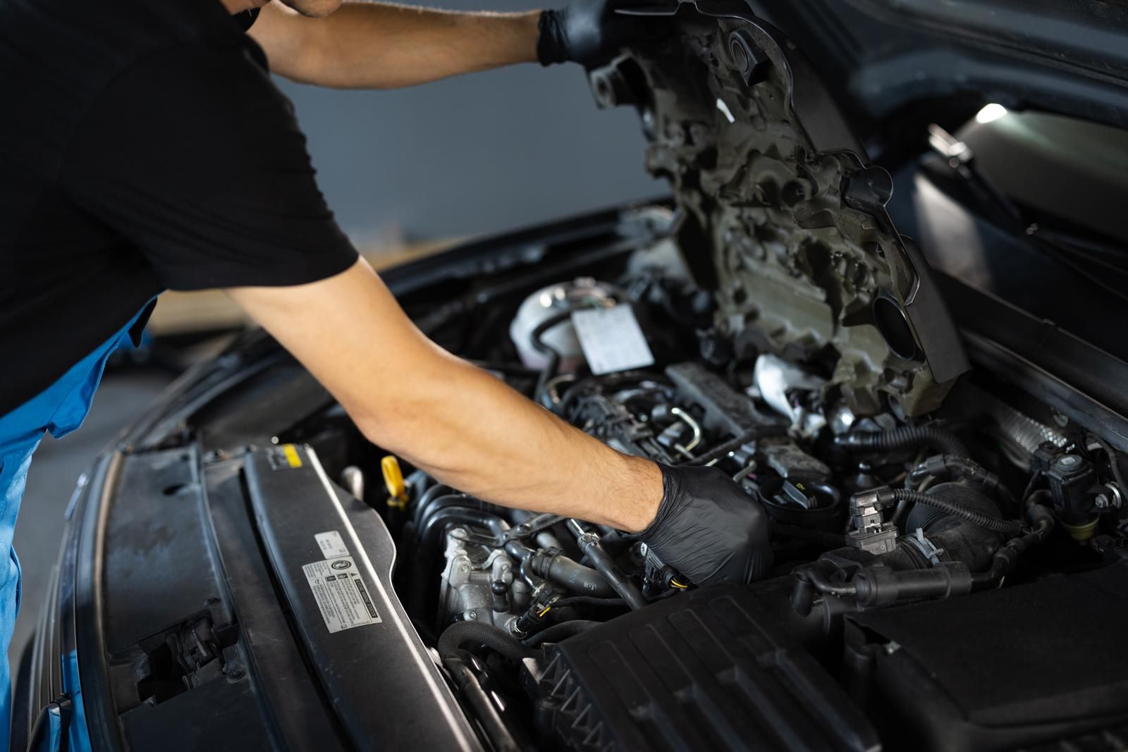 A technician working in an open engine bay